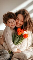 Smiling mother and son are hugging at home while holding a bouquet of red and white tulips, celebrating mother's day with love and affection