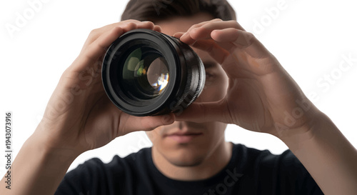 Man holding camera lens up to his face against white background