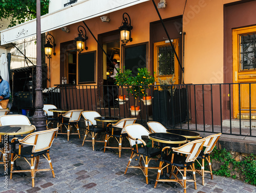 Cozy street with tables of cafe in quarter Montmartre in Paris, France. Architecture and landmarks of Paris. Postcard of Paris