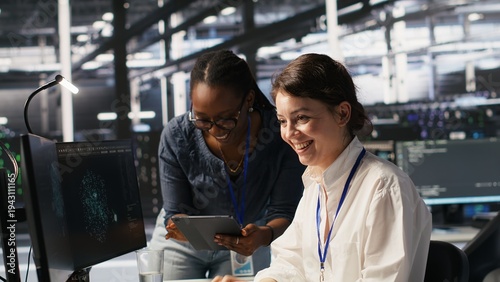 Photos Smiling technicians doing fist bump in data center after successful deployment of AI tools