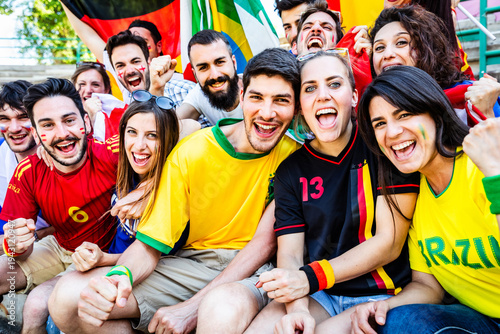 Diverse football fans cheering together at a stadium