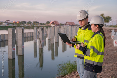 Tableau sur toile Civil Engineers Consult on Pile Driving in Water,Working at site of a large buil