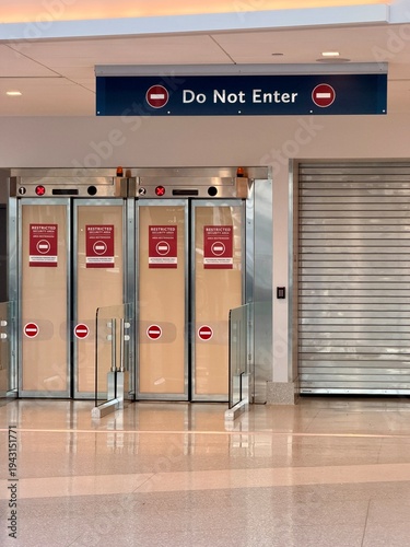 Fotografi Do Not Enter sign above exit doors in an airport