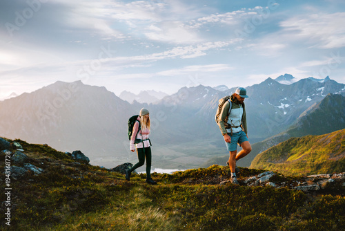 Couple man and woman hiking in Norway friends travel together in Lofoten islands on active summer vacations adventure healthy lifestyle, people  climbing mountains family camping tour outdoor