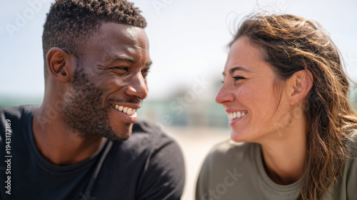 Couple smiling and looking at each other on sandy beach