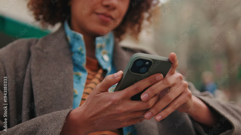 Fototapeta premium Person Using Smartphone Outdoors With Focused Hands