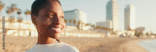 young woman with short hair in casual clothes walking at dawn near the sea, a joyful and happy active girl. Panoramic