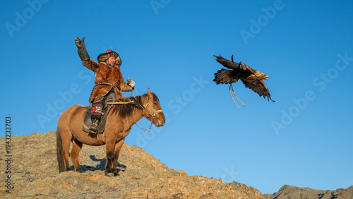 Golden Eagle taking off from a Mongolian eagle hunter (berkutchi) on a horse, Altai Mountains, Western Mongolia, Mongolia