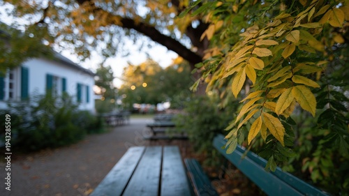 Lebhafte deutsche Herbst-Biergartenatmosphäre mit Bänken unter Kastanienbäumen und goldenem Laub