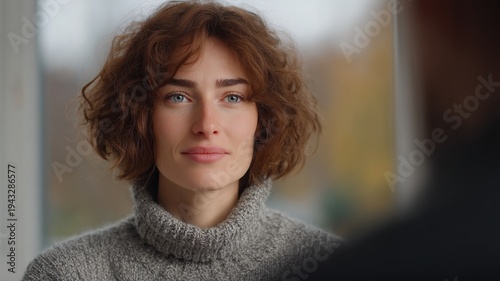 Frau nimmt an einer Business-Therapie-Sitzung in der Nähe eines großen Fensters in herbstlicher Umgebung teil