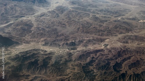 flying across landscape in northeastern part of Sultanate of Oman with desert, dried riverbeds and mountain landscape all around, small settlements are located in the valleys - 4k aerial video footage
