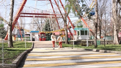 two little twin girls walking in the park in spring