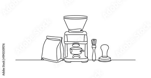 Compact coffee station setup with grinder centered on the counter, bag of beans propped against it, small brush and tamper