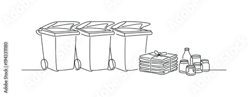 Row of large outdoor recycling containers with hinged lids slightly open, stack of sorted newspapers tied with string placed