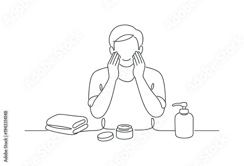 Man applying skincare products to his face with a towel and lotion nearby