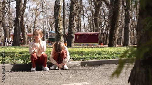 two little twin girls walking in the park in spring