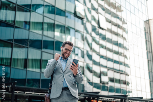 Wallpaper Mural Happy businessman celebrating success checking phone notification Torontodigital.ca