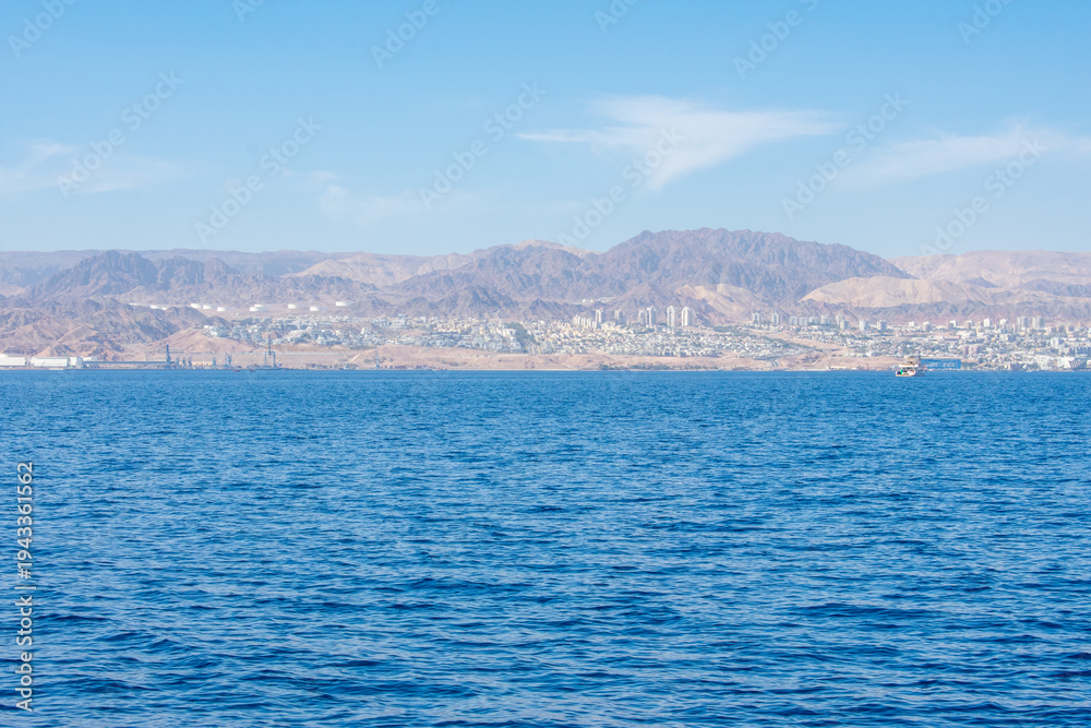 Fototapeta premium View from Aqaba in Jordan on Aqaba Gulf and Eliat In Israel. Israeli flag on Coast of Red Sea 