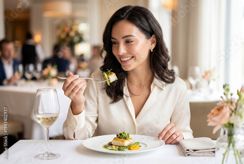 Elegant woman holding fork with salmon in fine dining setting