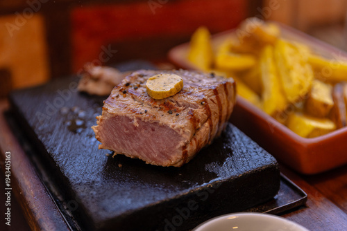 Foto High-resolution photograph of alpaca tenderloin served with roasted native potato strips on a plate in Arequipa