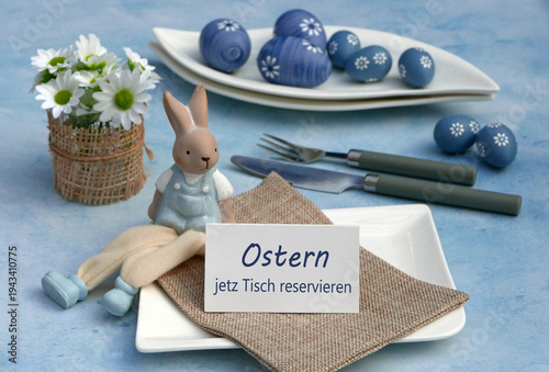 Reservierung: Tischreservierung zu Ostern mit Blumen, Osterhase, Ostereier, Teller und Besteck. Auf einer Karte steht der Text Ostern jetzt Tisch reservieren.