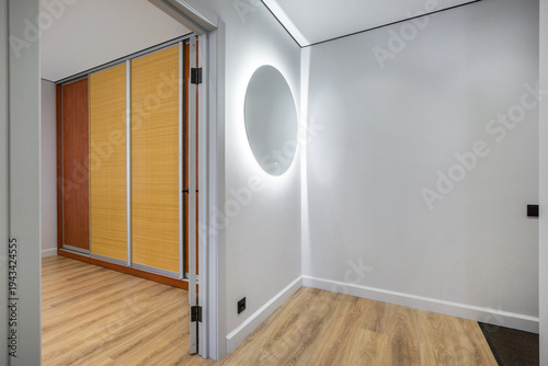Fotografi The scene shows a hallway leading to a storage closet with wooden doors