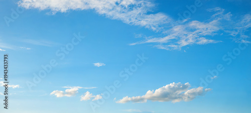 Beautiful light blue sky with space, framed by feather-light cirrus clouds above and cumulus clouds below.