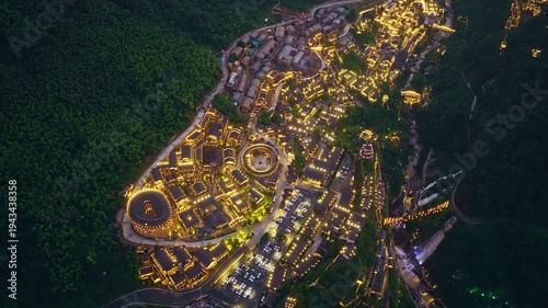 Night view of Wangxiangu resort with traditional illuminated architecture and mountain landscape in Jiangxi, China.