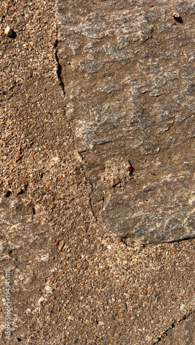 Natural rock surface with soil and small gravel forming an abstract earthy texture. Organic background useful for environmental or geology themed designs.
