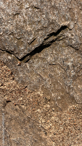 Natural rock surface with soil and small gravel forming an abstract earthy texture. Organic background useful for environmental or geology themed designs.