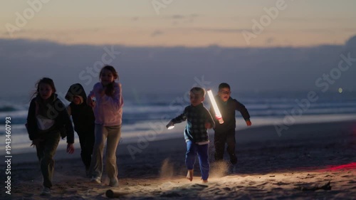 Group of children playing with a panda mascot on the beach at sunset