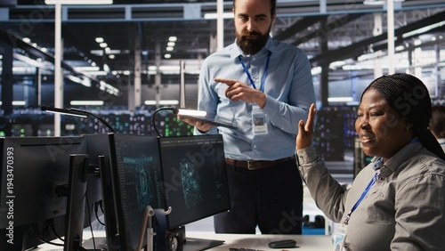 Принти на полотні Annoyed data center employee making rude hand gesture toward colleague during workplace disagreement