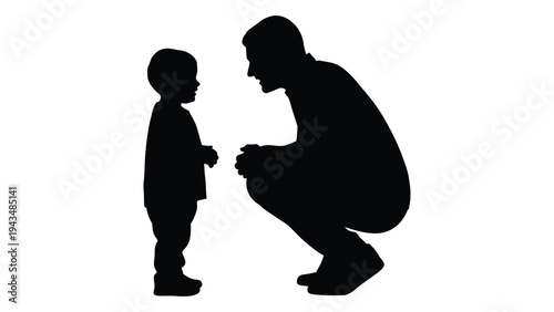A man crouches down to talk to a young boy