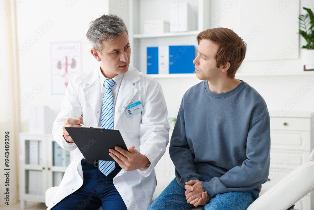 Obraz premium Urologist showing clipboard to patient on medical couch in clinic