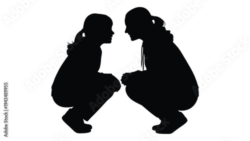 Two girls crouching and looking at each other
