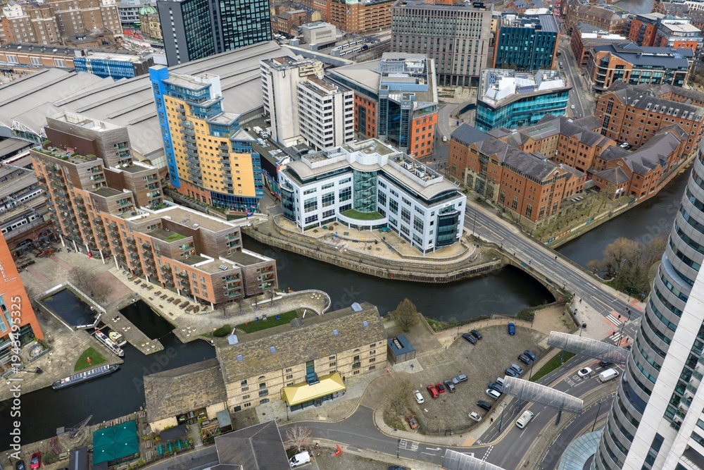 Fototapeta premium Drone aerial view of Royal Armouries Museum and Leeds Dock waterfront with River Aire modern offices apartments bridges and roads beneath cloudy sky