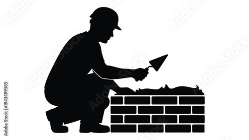 A man in a hard hat is laying bricks