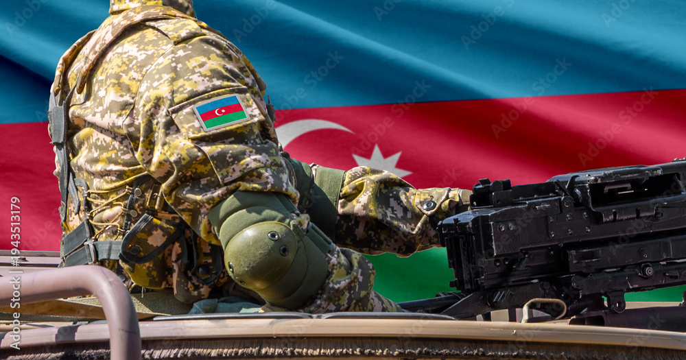 Fototapeta premium Azerbaijan national flag with soldier at machine gun turret in front of it. Closeup side view.