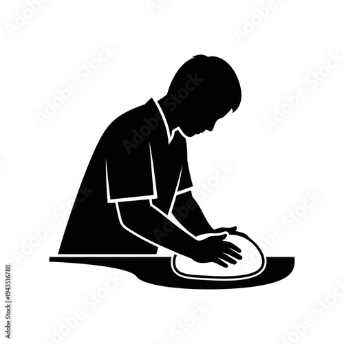 Man kneading dough on mat floor.
