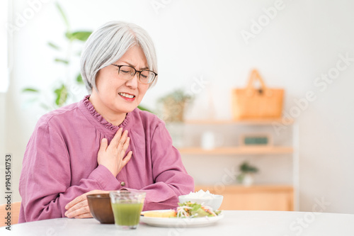 Foto A gray-haired senior woman choking while eating (aspiration pneumonia, swallowin