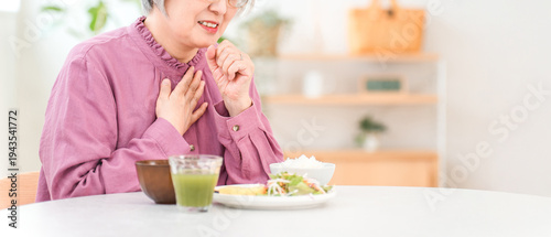 Obraz na plátně A gray-haired senior woman choking while eating (aspiration pneumonia, swallowin