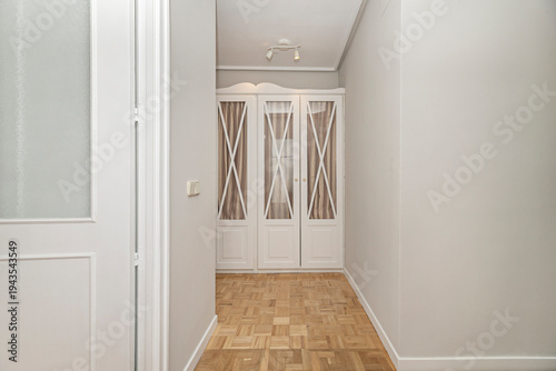 Schilderij op canvas Undecorated minimalist room, showcasing white built-in wardrobe modules of diffe