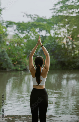 Young asian woman practicing yoga on nature. Girl meditating outdoors. Female with slim, strength and flexibility body. Healthy lifestyle. Vitality, calmness, relax, mindfulness and zen energy concept