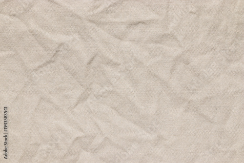 Wrinkled cotton fabric with creases, textured light beige textile, empty crumpled design background