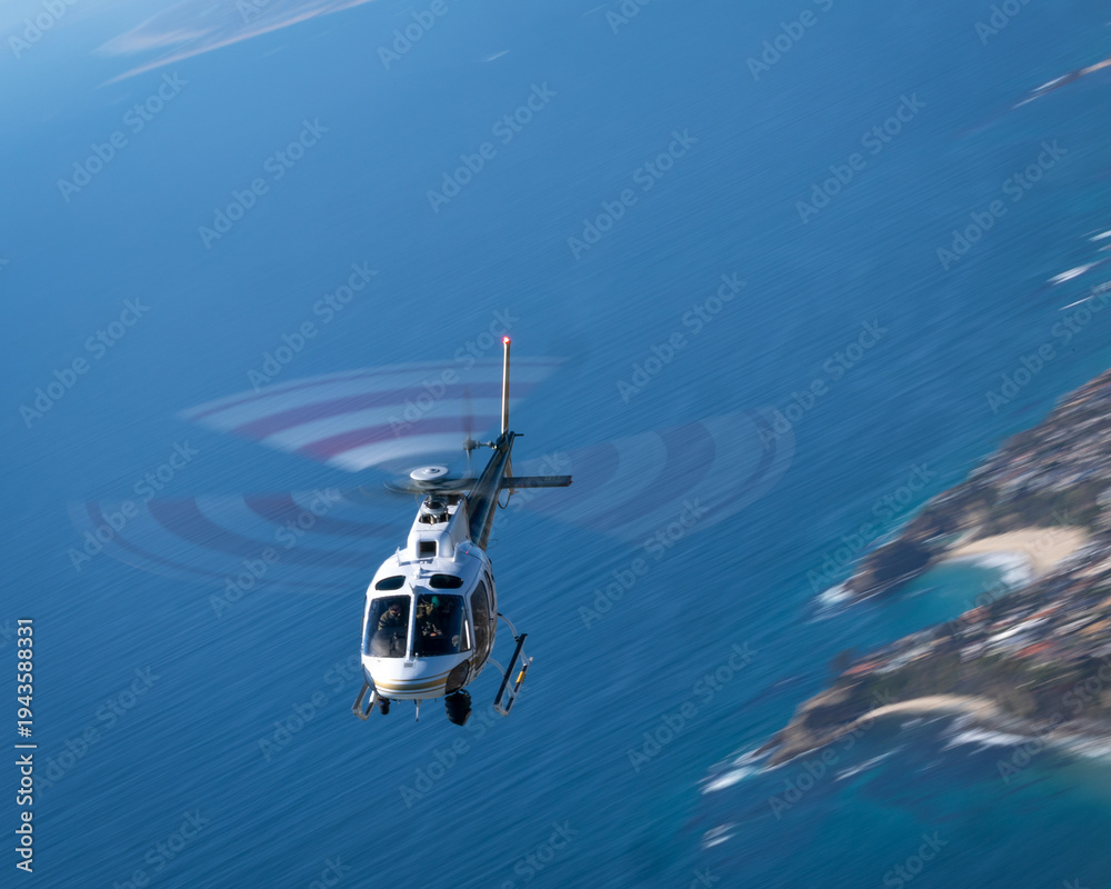 Fototapeta premium Helicopter (AS350) over the California coast, at very low shutter speed