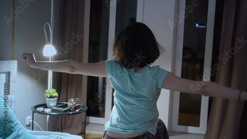 Bild auf Leinwand Woman stretching in bedroom at night with casual clothes, early morning rise