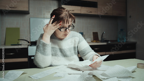 Stressed Woman Reviewing Bills and Receipts at Home Kitchen Table, The woman is surprised by the money spent