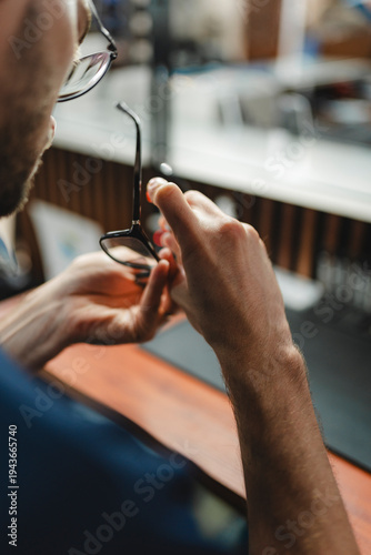Person checking eyeglasses for visual health and optics care