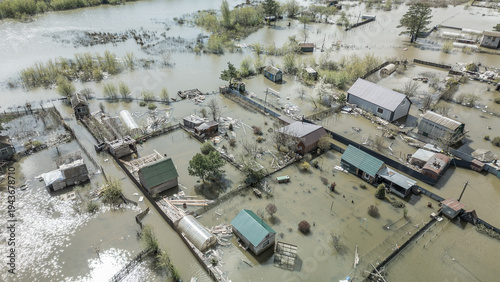 Spring flood disaster with fully submerged houses, flooded roads and overflowing waterways. The footage shows the dramatic impact of heavy rainfall and rising water levels on residential areas