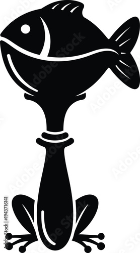 A black illustration of a smiling fish sits on a decorative spoon handle with frog feet.